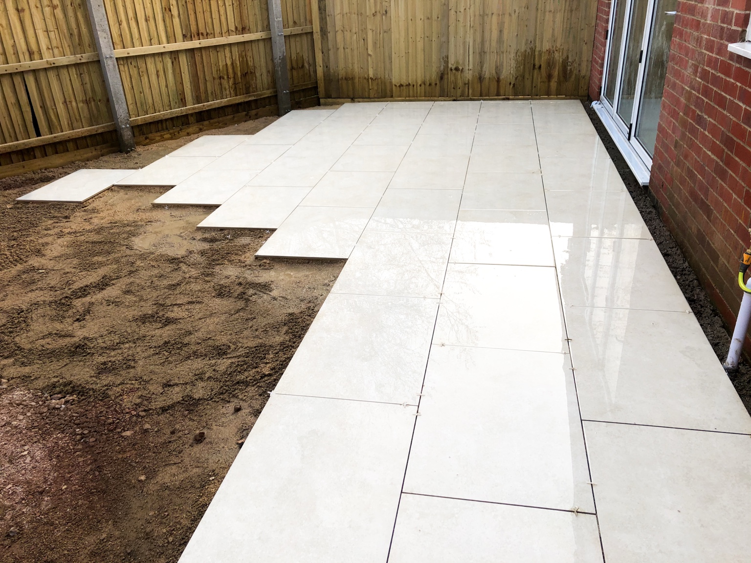 During Installation for Porcelain patio & artificial grass by Stonecrest Paving and Landscaping in Gloucester